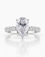 Sculptural pear moissanite ring with hidden halo and accented shoulders in polished 18K white gold | SARATTI