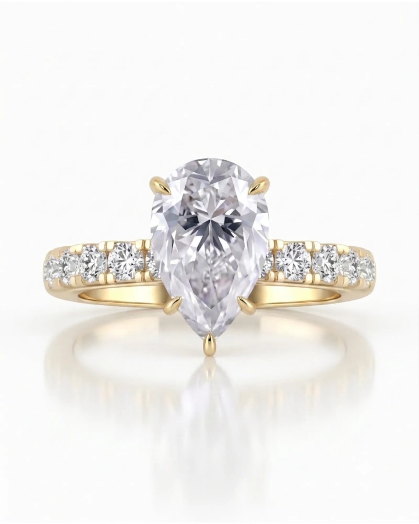 Sculptural pear moissanite ring with hidden halo and accented shoulders in polished 18K yellow gold | SARATTI