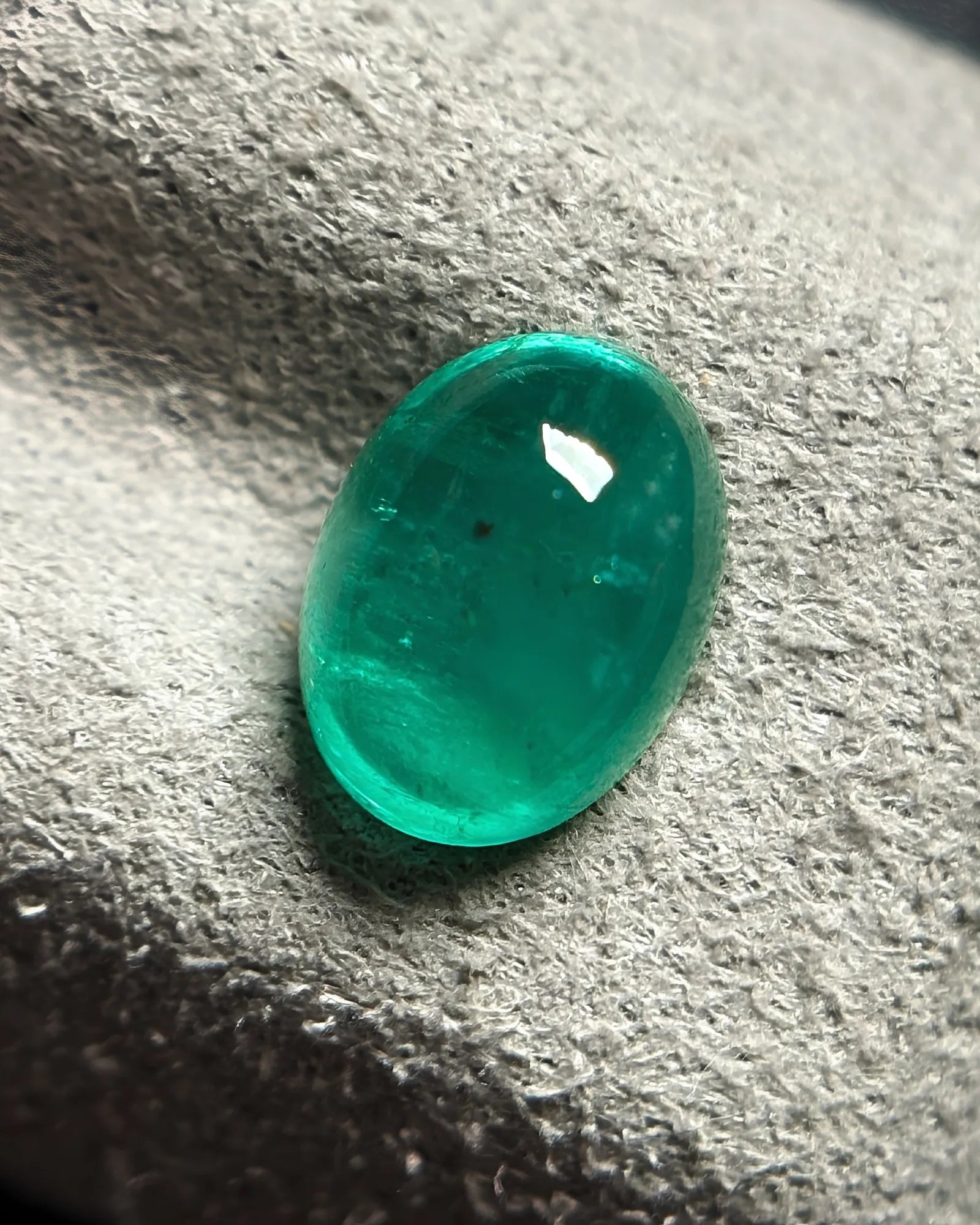 Semi-transparent Emerald cabochon showing visible natural inclusions | SARATTI