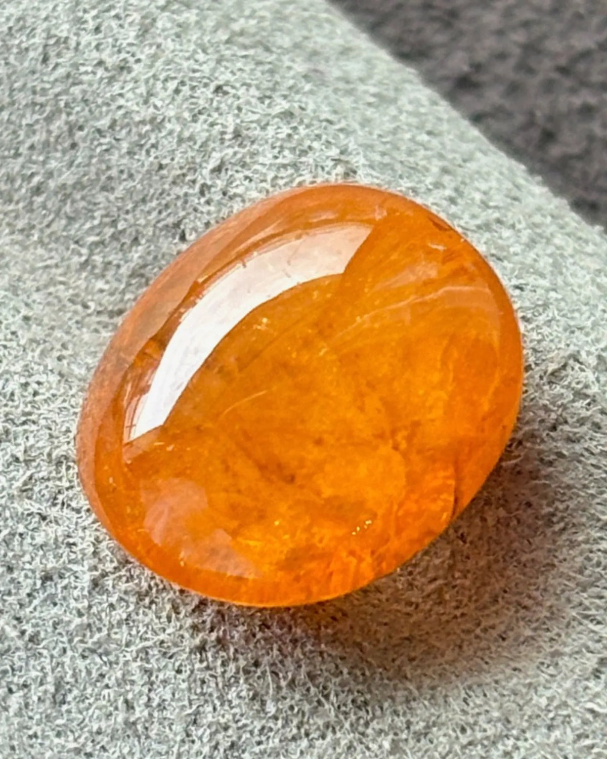 Side angle of 9.98ct oval Spessartine Garnet cabochon | SARATTI