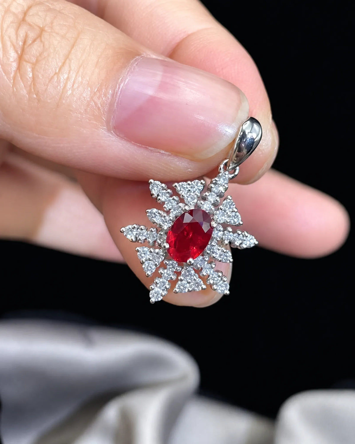 Side profile of ISADORA ruby diamond snowflake pendant showing raised gemstone and open setting structure | SARATTI