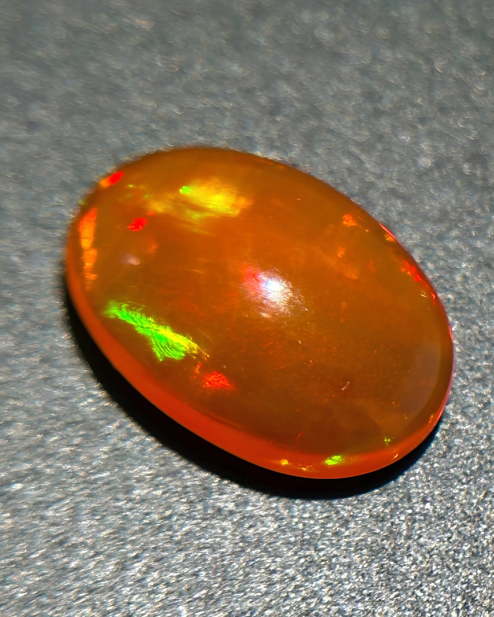 Side profile of Mexican Fire Opal oval cabochon with polished dome | SARATTI