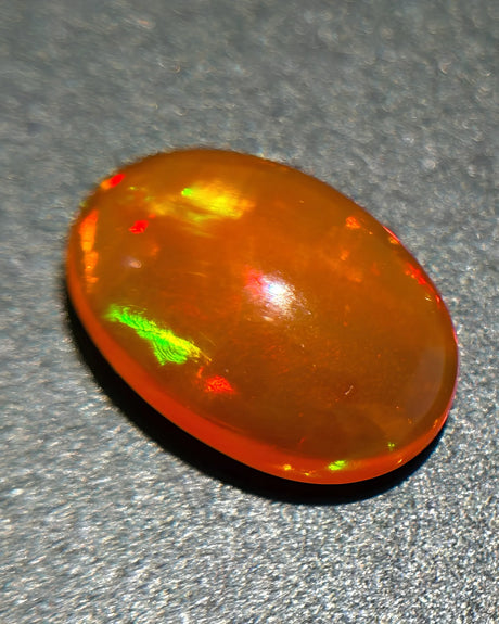 Side profile of Mexican Fire Opal oval cabochon with polished dome | SARATTI