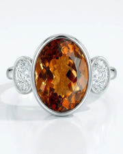 Smooth bezel setting frames the Imperial Topaz in a secure oval form in white gold | SARATTI