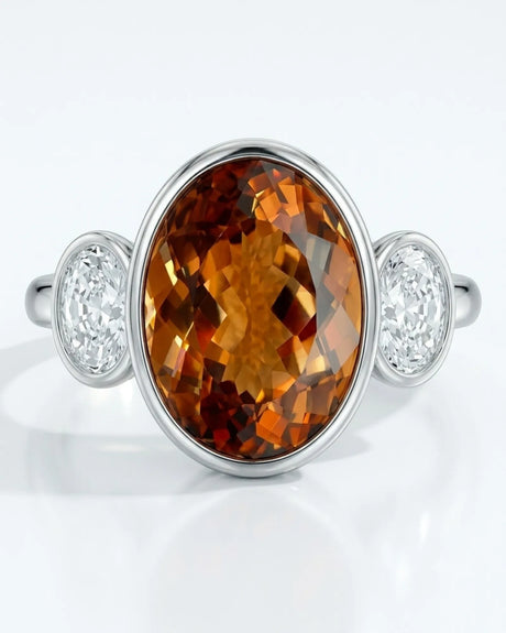 Smooth bezel setting frames the Imperial Topaz in a secure oval form in white gold | SARATTI