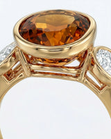 Smooth bezel setting frames the Imperial Topaz in a secure oval form in yellow gold | SARATTI