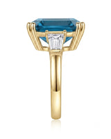 Three-stone blue topaz engagement ring with architectural baguette accents in 18K yellow gold | SARATTI