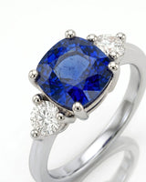 Three stone sapphire ring with round diamond accents in polished platinum | SARATTI