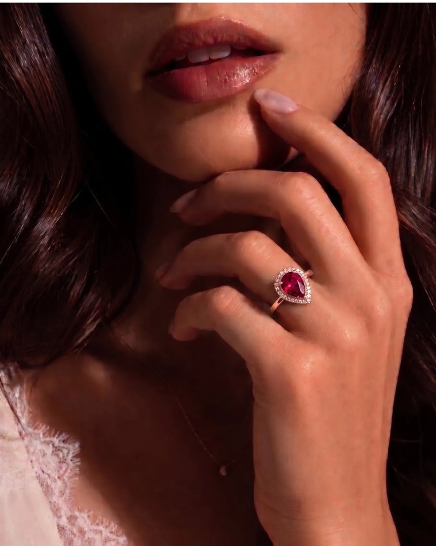 Vibrant red-pink pear tourmaline ring framed by diamonds in 18K rose gold | SARATTI