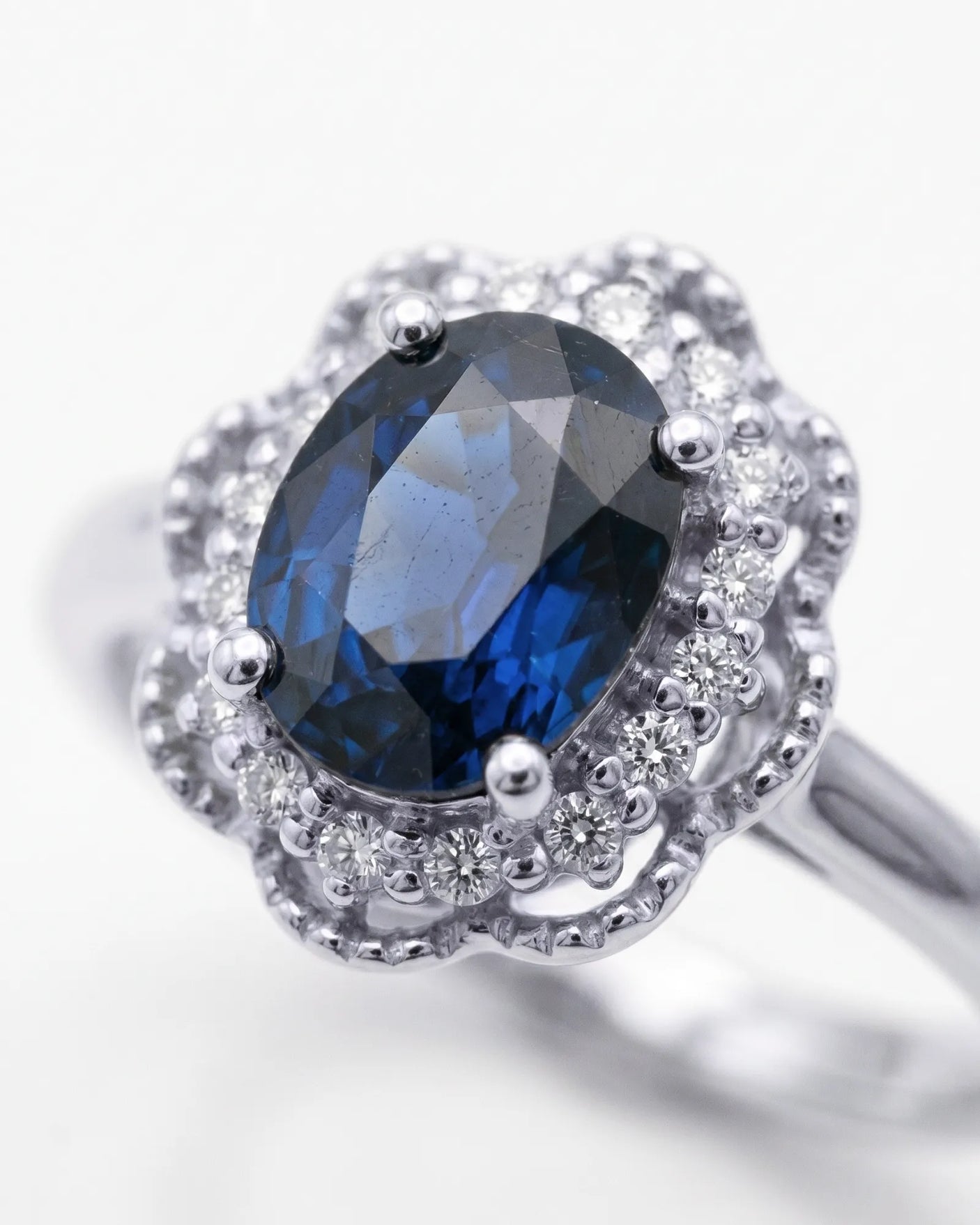 Vintage-inspired sapphire ring with floral diamond halo in polished white gold | SARATTI