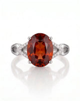 Vivid orange oval garnet ring with natural diamond shoulders in platinum | SARATTI