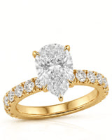 Yellow gold pear cut moissanite engagement ring with round side stones and slim polished band | SARATTI