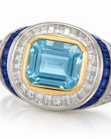 Azzurro Regent emerald-cut Aquamarine cocktail ring setting in yellow and white gold, close-up of baguette diamonds and blue sapphire channels | SARATTI