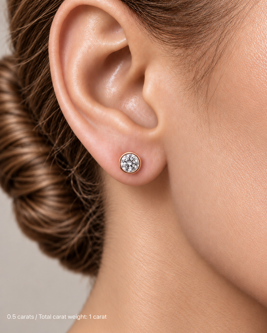1.00 ct. tw. lab-grown round diamond full-bezel studs in 14K rose gold on fair skin | SARATTI