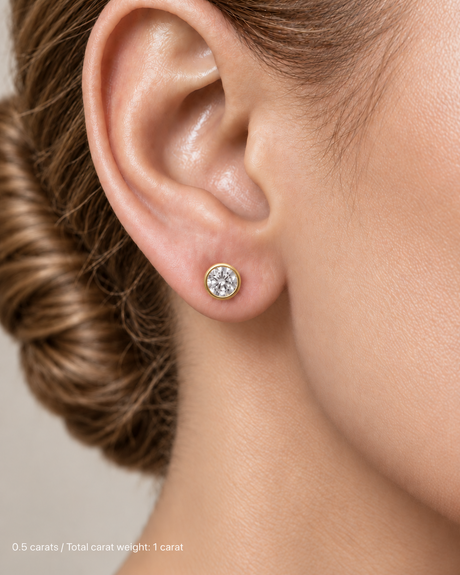 1.00 ct. tw. lab-grown round diamond full-bezel studs in 14K yellow gold on fair skin | SARATTI