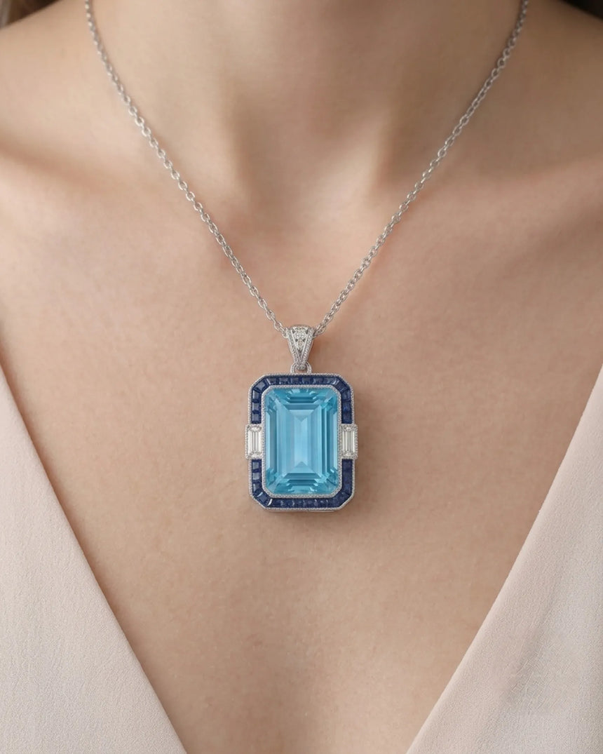 Bleu Meridian emerald-cut Aquamarine sapphire and diamond necklace setting in white gold, worn at the neckline | SARATTI