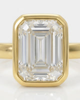 Natural emerald cut diamond full bezel ring in yellow gold close-up | SARATTI