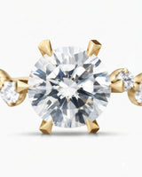 Joan 1 carat round natural diamond six-prong engagement ring in 18K yellow gold, macro detail of graduated round brilliant diamond side stones | SARATTI