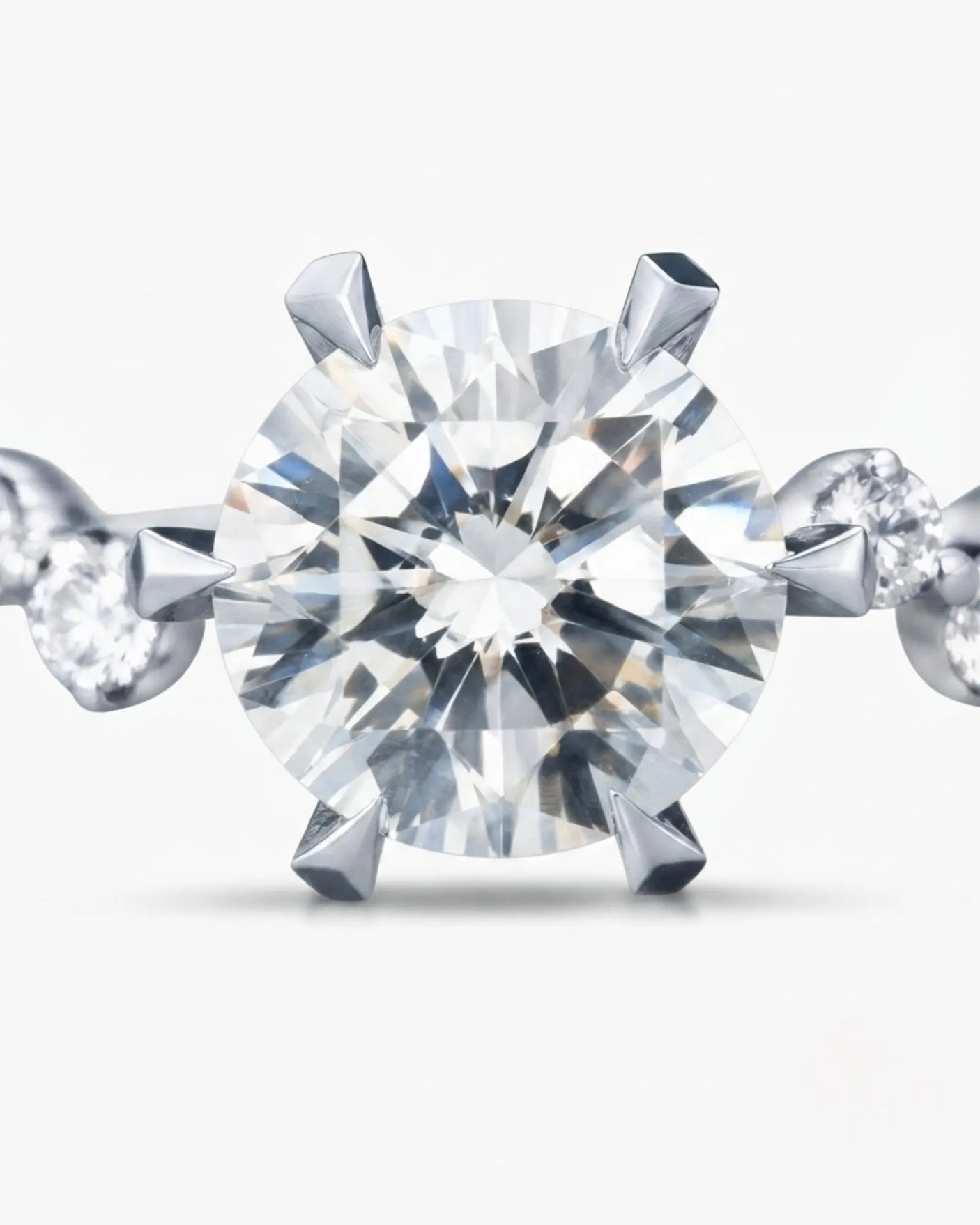 Joan 1 carat round natural diamond six-prong engagement ring in platinum, macro detail of graduated round brilliant diamond side stones | SARATTI
