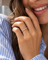 Lifestyle portrait of a woman wearing the round diamond half eternity band in 18K yellow gold | SARATTI