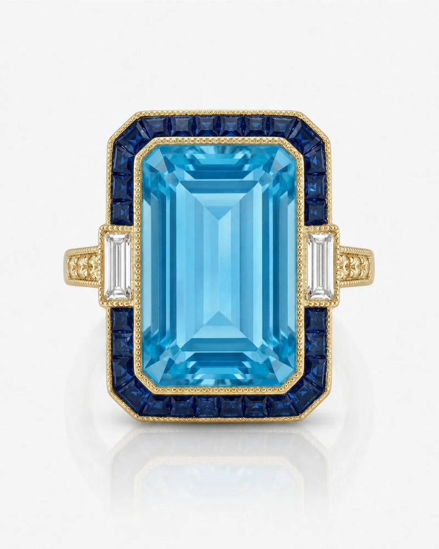 Saphira Line emerald-cut Aquamarine ring setting in yellow gold, front view with blue sapphire halo and baguette side diamonds | SARATTI