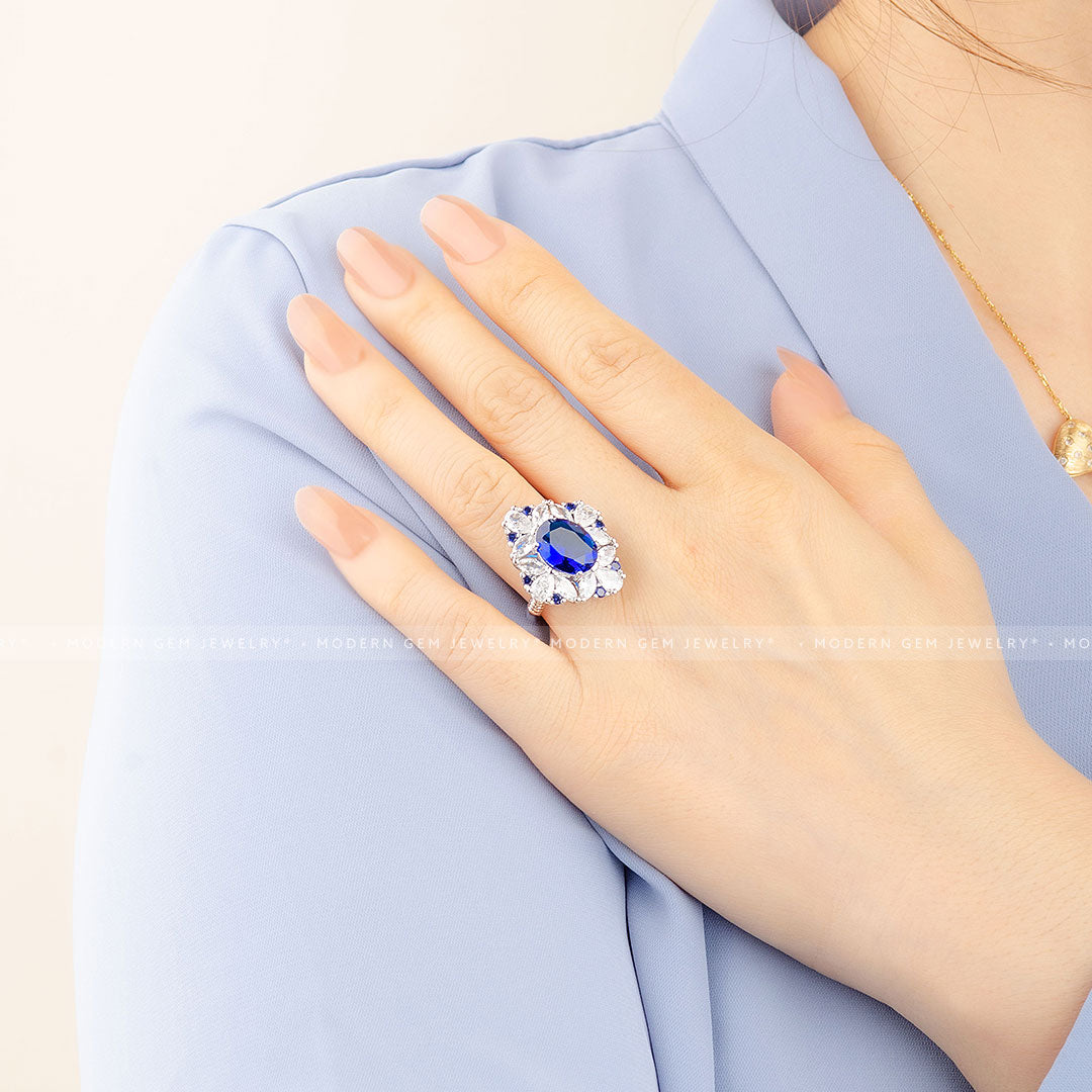 Oval Royal Blue Cocktail Ring with Sapphire and Diamond Accent Stones in 18K White Gold on Woman's Hand Wide Shot | Saratti  