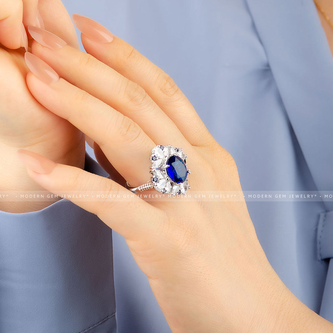 Oval Royal Blue Cocktail Ring with Sapphire and Diamond Accent Stones in 18K White Gold on Woman's Hand Side Shot | Saratti